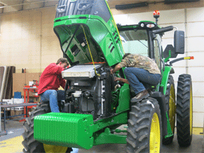 students working on tractor